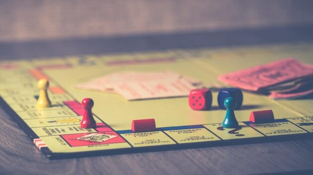 A group of leaders engaged in a strategic board game, symbolizing the science of leadership through strategic thinking and decision-making.