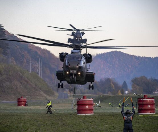 Two team members guiding helicopters in, symbolizing the execution of culture change strategies through teamwork and precision.